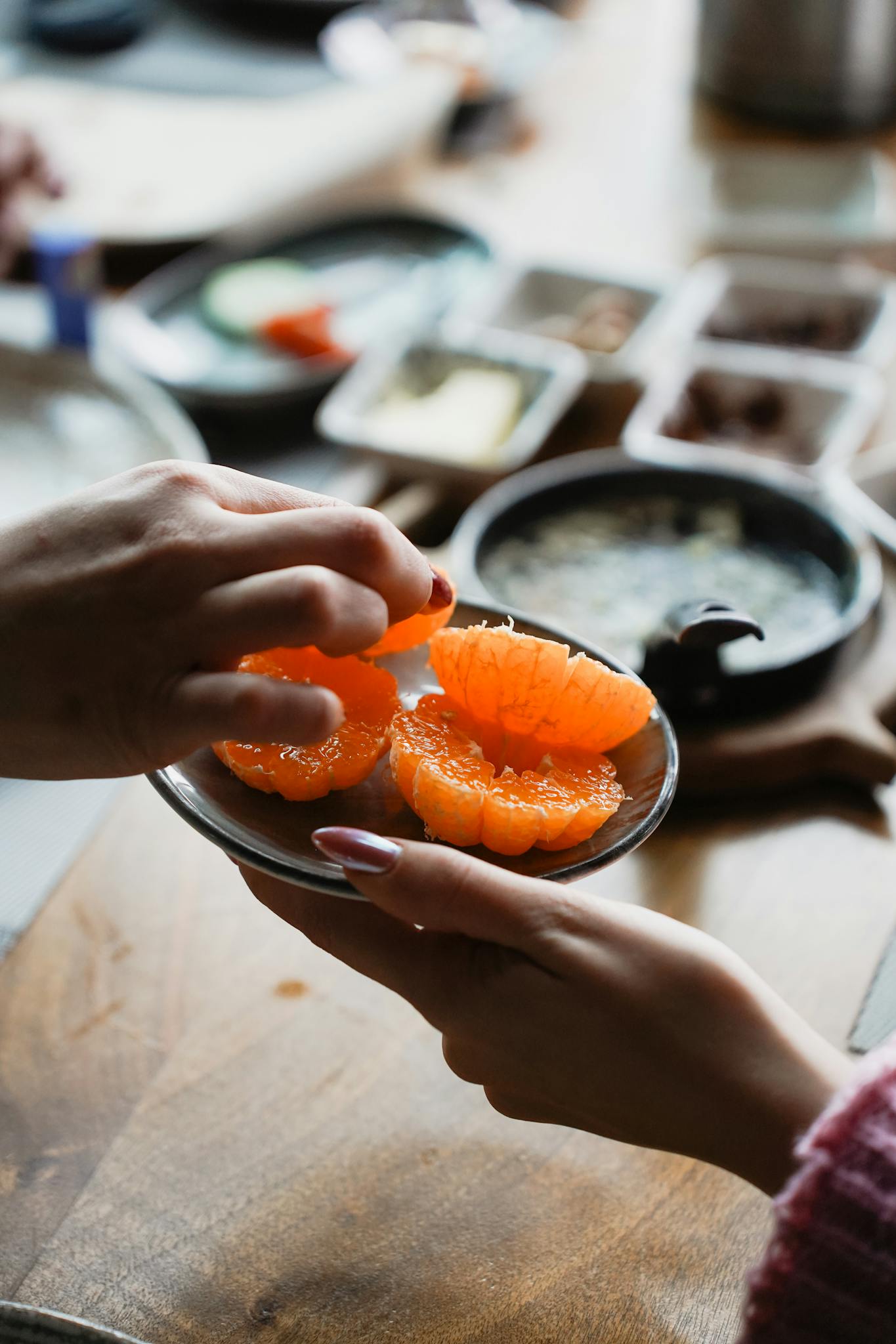 Vibrant citrus slices in a bowl, held by two hands, perfect for healthy living themes.